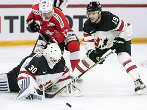 Switzerland's Reto Suri fights for the puck against Canada's Ben Scrivens and Gilbert Brule during the 2017 Karjala Cup on Nov. 8, 2017