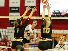 SAIT middle Taylor Ellis fires a ball over the block of Olds College on Friday night.