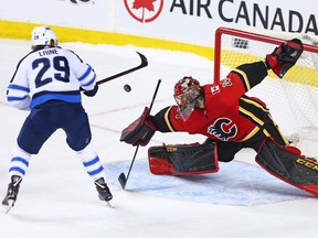 Calgary Flames goaltender Mike Smith stops this shot by Patrik Laine during a shoot-out in NHL action at the Scotiabank Saddleome in Calgary on Saturday January 20, 2018.