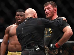 Stipe Miocic (right) reacts after defeating Francis Ngannou by unanimous decision in their Heavyweight Championship fight during UFC 220 at TD Garden in Boston on Saturday, Jan. 20, 2018.