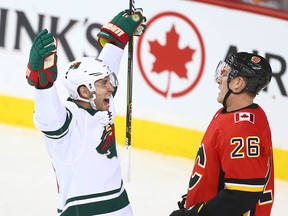 Jason Zucker celebrates the Wild's game-winning goal in front of Flames Michael Stone at the Saddledome on Oct. 21, 2017.