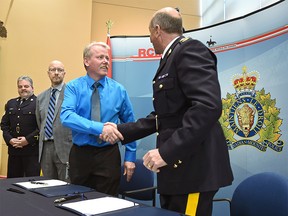 Shaking hands, RCMP Deputy Commissioner Todd Shean, commanding officer and Trevor Tychkowsky (L), President of the Alberta Provincial Rural Crime Watch, after signing a memorandum of understanding outlining the roles each organization will play in keeping rural communities safe in the province, at "K" Division in Edmonton, February 15, 2018. Ed Kaiser/Postmedia For Catherine Griwkowsky story running Feb. 16, 2018