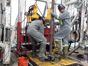 Trinidad Drilling floor hand Tobias Metz, left, and Ivan Popovic work around the drill at the drilling rig at a Legacy Oil and Gas site southwest of Turner Valley on April 28. 2014.