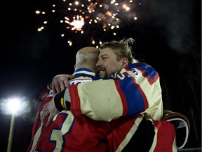 Brent Saik, right, hugs James McCormack as the World's Longest Hockey Game comes to a close near Sherwood Park, Alta., on Monday Feb. 19, 2018.