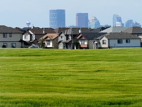 The Calgary City skyline peeks out from behind houses in the NE community of Saddle Ridge. Stuart Dryden/Calgary Sun/QMI Agency