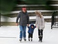 Dennis James and Natalie Curran give their son William, 2, a helping hand as they headed towards the skating rink  in Olympic Plaza as snow fell in Calgary on Tuesday, December 19, 2017.  Gavin Young/Postmedia