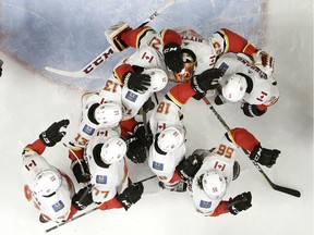 Calgary Flames goalie David Rittich, of the Czech Republic, top, is congratulated by teammates after they defeated the Nashville Predators in an NHL hockey game Thursday, Feb. 15, 2018, in Nashville, Tenn.