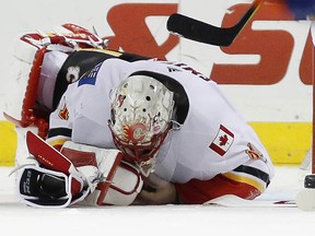 Calgary Flames goaltender Mike Smith (41) rolls over on the ice after he was injured during the third period of an NHL hockey game against the New York Islanders in New York, Sunday, Feb. 11, 2018. The Flames defeated the Islanders 3-2 on Matthew Tkachuk's game-winning goal. (AP Photo/Kathy Willens) ORG XMIT: NYKW113