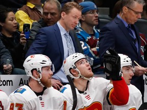Calgary Flames head coach Glen Gulutzan, watches as the Flames face the Colorado Avalanche during the first period of an NHL hockey game Wednesday, Feb. 28, 2018, in Denver.