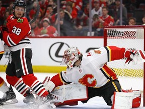 Mike Smith #41 of the Calgary Flames makes a save against Ryan Hartman #38 of the Chicago Blackhawks at the United Center on February 6 2018 in Chicago, Illinois.