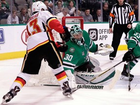 Dallas Stars goalie Ben Bishop (No. 30) deflects a shot from Calgary Flames left wing Johnny Gaudreau, as Stars defencemen Marc Methot looks to clear th puck during the second period of an NHL hockey game Tuesday, Feb. 27, 2018, in Dallas.