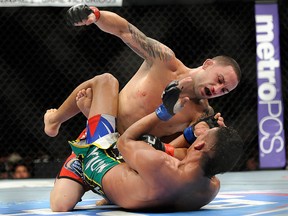 Frankie Edgar punches Charles Oliveira during their UFC 162 featherweight bout at the MGM Grand Garden Arena on Saturday, July 6, 2013, in Las Vegas. (AP Photo/David Becker)