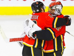 Flames goalie Jon Gillies is congratulated by teammate Matthew Tkachuk following a home-side win at the Saddledome on Saturday, Feb. 24, 2018.