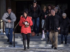 Marilyn Thompson, in red, sister of Gordon Klaus, leaves court with family and friends after Joshua Frank and Jason Klaus were sentenced in Red Deer, Alta., Wednesday, Feb. 14, 2018. The pair were found guilty of first-degree murder in the shooting deaths of Klaus's parents and sister in a rural home near Castor, Alberta in December 2013.