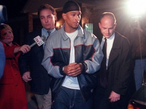 Rae Carruth is escorted to a waiting car in Jackson, Tennessee, following his arrest by FBI agents in this Dec 15, 1999 photo