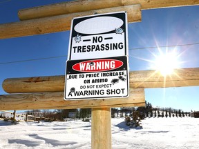 A warning sign is posted on a fence at the entrance to a rural property north of Okotoks, Alberta, south of Calgary on Tuesday, February 27, 2018.