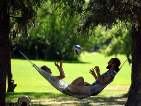 Ariane Coulombe and Patrick Alexandre share some quiet time in a hammock in Riley Park in the shade in northwest Calgary on Sunday July 2, 2017.The couple are visiting Calgary on holiday from Quebec. Jim Wells//Postmedia
