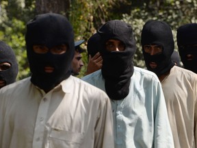Alleged fighters for the Islamic State and Taliban walk being presented to the media at the police headquarters in Jalalabad on October 3, 2017. Afghan police said 10 alleged Islamic state fighters, including two non-Afghans, and four Taliban militants were arrested during an operation in Nangarhar province. / AFP PHOTO / NOORULLAH SHIRZADA (Photo credit should read NOORULLAH SHIRZADA/AFP/Getty Images)