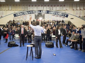 Prime Minister Justin Trudeau waves to the crowd following a town hall in Nanamio, B.C., Friday, Feb. 2, 2018 as a bottle of orange juice lays on the floor beside him that was thrown at him by a protester. THE CANADIAN PRESS/Jonathan Hayward ORG XMIT: JOHV108