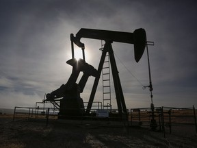 A pumpjack works at a well head on an oil and gas installation near Cremona, Alta.