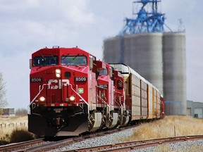 CPR, Canadian Pacific auto train rolls by grain elevators at Carseland, AB. Handout/ CP Rail