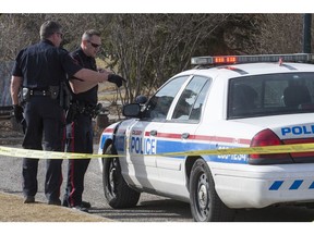 CALGARY, AB -- Officers talk outside the cruiser holding their suspect after an officer-involved shooting in Stanley Park on March 20, 2016. Crystal Schick/Crystal Schic