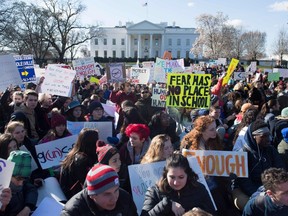 Thousands of local students sit for 17 minutes in honor of the 17 students killed last month in a high school shooting in Florida, during a nationwide student walkout for gun control in front the White House in Washington, DC, March 14, 2018.