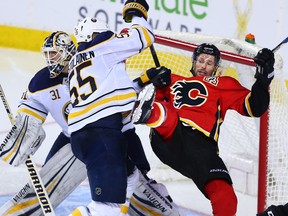 Flames Troy Brouwer is dumped by the Buffalo Sabres Rasmus Ristolainen at the Saddledome on Jan. 22, 2018.