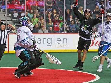 The Calgary Roughnecks' Tyson Bell celebrates his team's goal on Rochester Knighthawks goaltender Matt Vinc during NLL action at the Scotiabank Saddledome in Calgary on Saturday March 17, 2018.