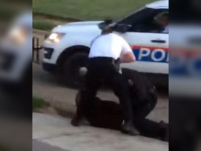 In this screenshot, a cellphone video captures Columbus Police apprehending a suspect as one officer appears to kick the restrained individual's head.