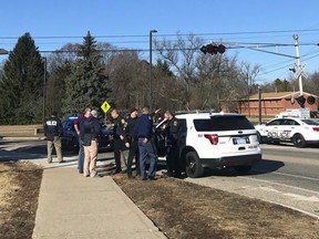 Authorities stand on the campus of Central Michigan University during a search for a suspect, in Mount Pleasant, Mich., Friday, March 2, 2018.