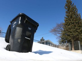 A City of Caglary black bin used to collect garbage is shown in an alley in Acadia in Calgary on Saturday, March 10, 2018. A city committee will look at hiking monthly rates for the black cart garbage pickup service by $4 to $5 and charging currently fully subsidized condo dwellers.Jim Wells/Postmedia