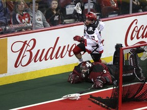 Calgary Roughnecks transition Zach Currier (77) jumps over Colorado Mammoth goalie Dillon Ward as the Calgary Roughnecks play the Colorado Mammoth in first-half National Lacrosse League action at the Scotiabank Saddledome on Friday, Dec. 29, 2017 in Calgary, Alta. The game was tied 4-4 after 30 minutes of play. Britton Ledingham/Postmedia Network