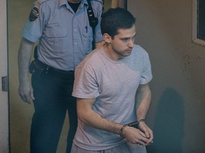 Guillaume Gelinas is escorted into the prisoner's bus as he leaves the Joliette courthouse after being charged with the murder of his father Luc Gélinas and his partner 35-year-old Julie Lemieux outside Montreal on Monday, February 17, 2014.