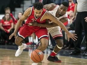 Brock Badgers' Tyler Brown, left, and Calgary Dinos' David Kapinga fight for a loose ball during quarterfinal action in the USports men's national championship in Halifax on Thursday, March 8, 2017. (THE CANADIAN PRESS/Darren Calabrese)