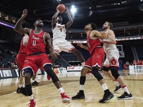 Calgary Dinos' Mambi Diawara, centre, puts up a shot in front of Brock Badgers' Johneil Simpson, left, and Dani Elgadi during the USports men's basketball national championship in Halifax on Thursday, March 8, 2017. (THE CANADIAN PRESS/Darren Calabrese)