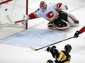 Pittsburgh Penguins Justin Schultz fires the winning goal in the overtime past Flames goaltender Jon Gillies in Pittsburgh on Monday, March 5, 2018.