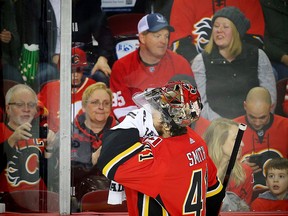 Calgary Flames goaltender Mike Smith wipes his face during a break in play at the Scotiabank Saddledome in Calgary on Sunday, March 11, 2018. (Al Charest/Postmedia)