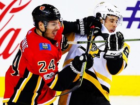 Calgary Flames Travis Hamonic battles against Sidney Crosby of the Pittsburgh Penguins during NHL hockey at the Scotiabank Saddledome in Calgary on Thursday, Nov. 2, 2017.