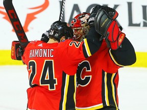 Calgary Flames goaltender Mike Smith celebrates with teammate Travis Hamonic after defeating the Edmonton Oilers at the Scotiabank Saddledome on Tuesday, March 13, 2018.