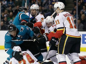 Members of the San Jose Sharks and Calgary Flames shove each other near the Calgary goal during the second period of an NHL hockey game Saturday, March 24, 2018, in San Jose, Calif. (AP Photo/Marcio Jose Sanchez)