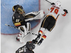 Micheal Ferland of the Calgary Flames falls to the ice after trying to put a rebound past Marc-Andre Fleury and Brayden McNabb of the Vegas Golden Knights in the second period of their game at T-Mobile Arena on March 18, 2018 in Las Vegas, Nevada. The Golden Knights won 4-0.