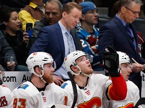Calgary Flames coach Glen Gulutzan, back, watches as the Flames lose to the Colorado Avalanche on Wednesday, Feb. 28, 2018, in Denver.