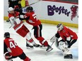 Ottawa Senators Mark Borowiecki (74) checks Carolina Hurricanes' Justin Williams (14) in front of Senators goaltender Mike Condon (right) during first period NHL hockey action in Ottawa, Saturday, March 24, 2018.