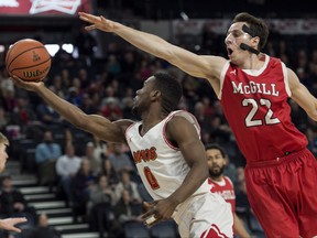 Calgary Dinos' David Kapinga, left, shoots as McGill Redmen's Francois Bourque defends during the first half of semifinal action in the USports men's basketball national championship in Halifax on Saturday, March 10, 2018. THE CANADIAN PRESS/Darren Calabrese ORG XMIT: DBC111