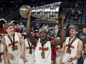 Calgary Dinos' Mambi Diawara, centre, hoists the W.P. McGee trophy while celebrating with teammates after defeating the Ryerson Rams to win the U Sports men's basketball national championship in Halifax on Sunday, March 11, 2018. (DARREN CALABRESE/The Canadian Press)