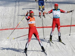 Canada's Brian McKeever (right) and guide Russell Kennedy celebrate after winning the men's 1.5k sprint classic, visually impaired, cross-country skiing at the 2018 Winter Paralympics in Pyeongchang, South Korea, Wednesday, March 14, 2018.
