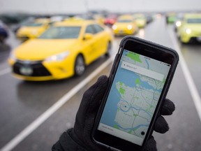 The Uber app is displayed on an iPhone as taxi drivers wait for passengers at Vancouver International Airport, in Richmond, B.C., on Tuesday March 7, 2017. THE CANADIAN PRESS/Darryl Dyck