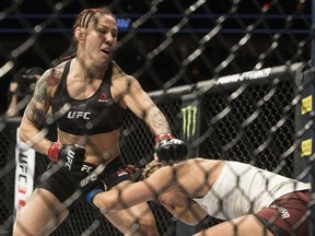Cris "Cyborg" Justino, left, connects with a left hook against Yana Kunitskaya during their featherweight championship mixed martial arts bout at UFC 222 on Saturday, March 3, 2018, in Las Vegas.