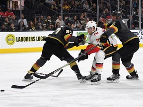 Mark Jankowski of the Calgary Flames skates with the puck against Vegas Golden Knights defenders at T-Mobile Arena on March 18, 2018